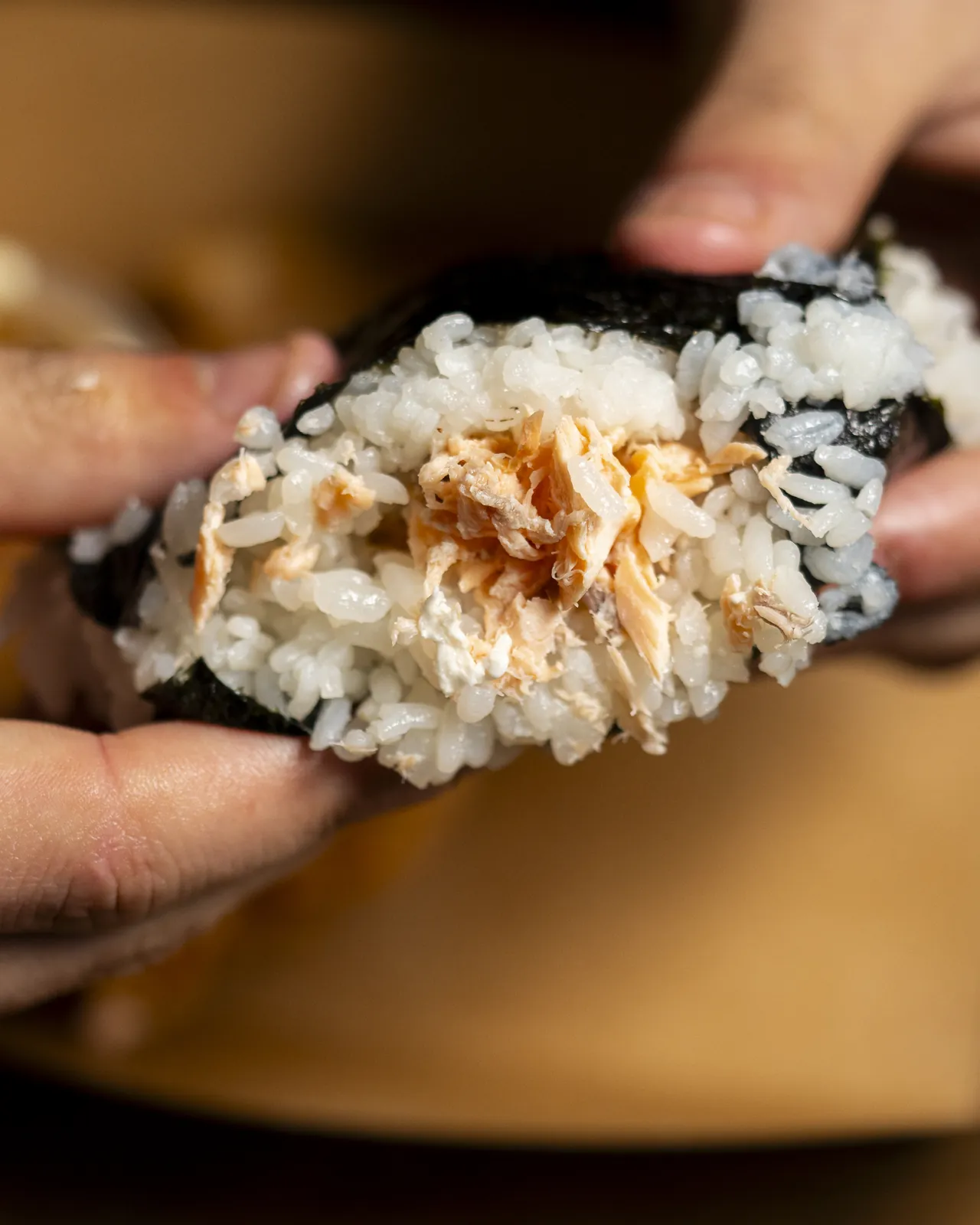 Main tenant un onigiri enveloppé de nori