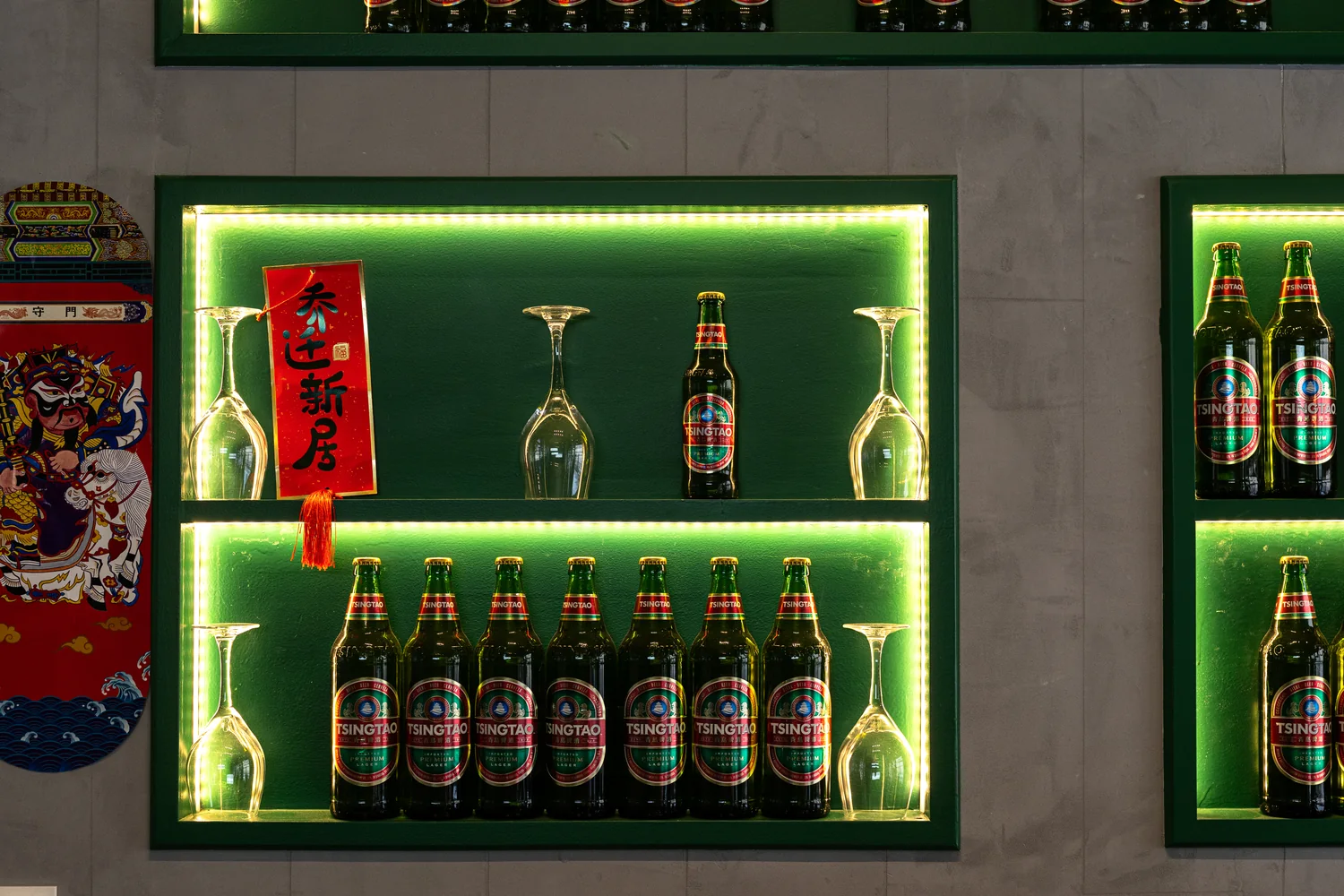 Le bar des Petites Cocottes et son néon vert, bières Tsingtao alignées