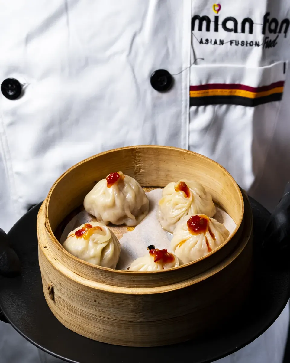 Le chef du Mian Fan Montparnasse présente un panier vapeur de dim sum faits maison