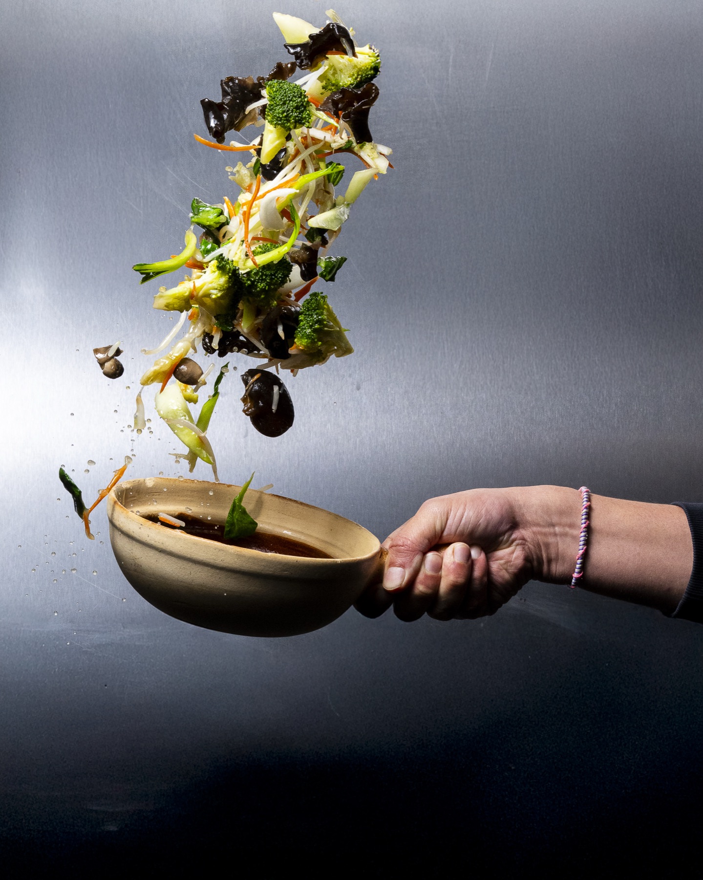 Sauté de légumes lancés en l'air depuis le wok du chef Mian Fan